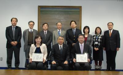 鈴木学長（中央前）を囲んで記念撮影（受賞者右前：荒木教授、受賞者左前：李職員）