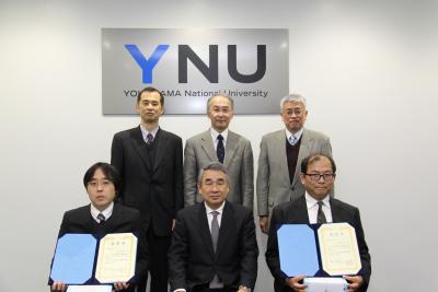 (前列左から)金井准教授、鈴木学長、多々見教授、(後列左から)今井部長、國分理事、清水理事