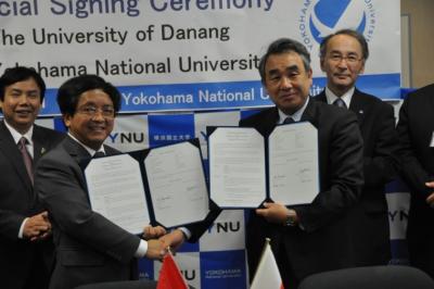 協定書を手に、固く握手するNAM学長と鈴木学長