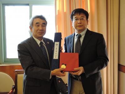 記念品を交換する鈴木邦雄学長(左)と陳群学長(右)