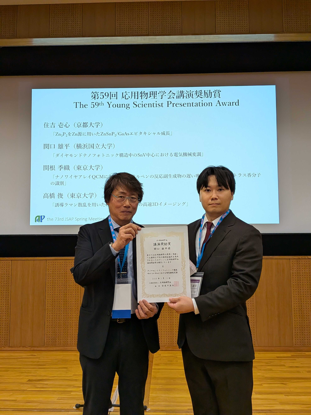 関口雄平 助教（右）と応用物理学会会長 安達千波矢 教授（左）