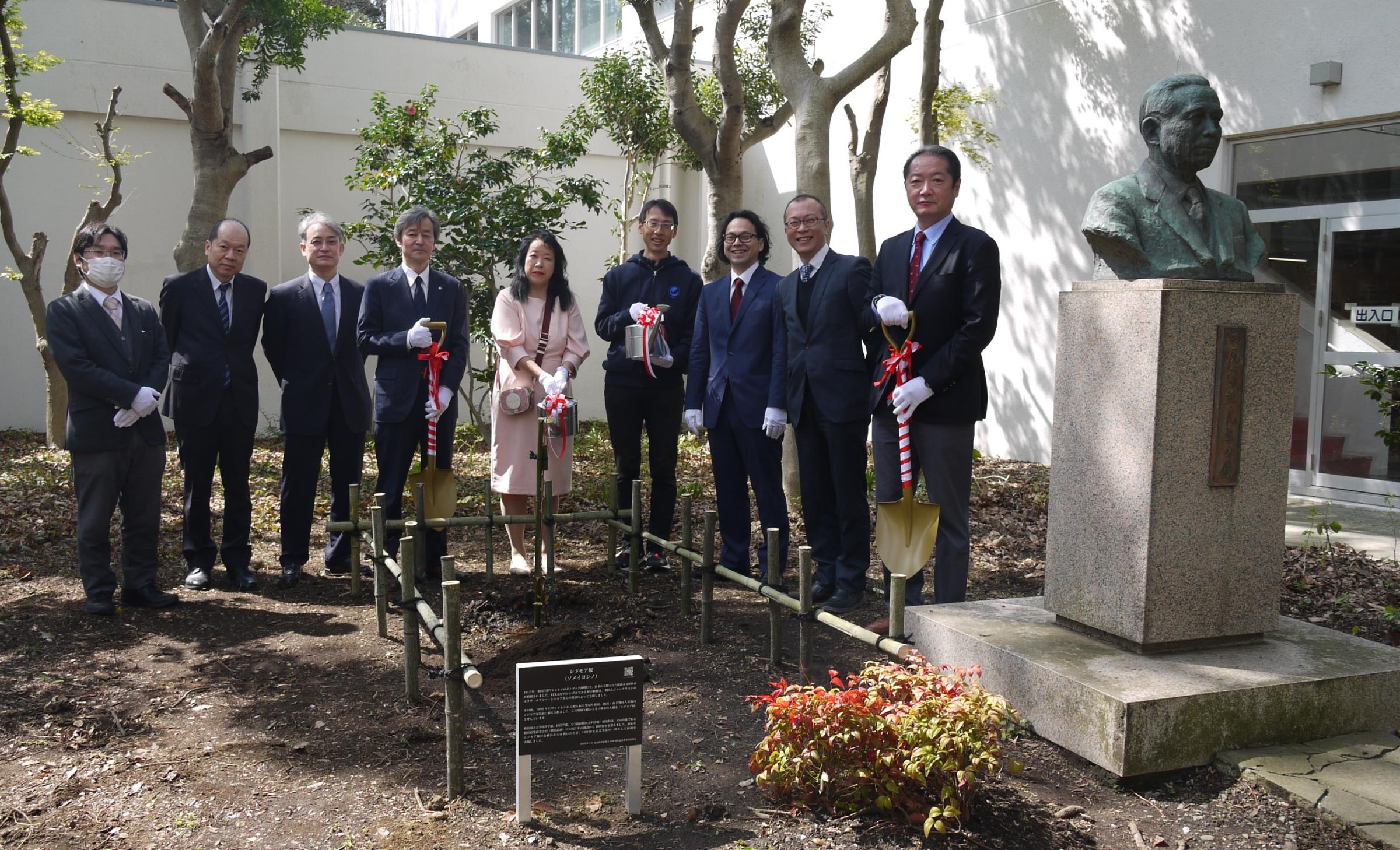 集合写真 左から、邉実行委員長、渡邉法律系長、佐藤研究院長、梅原学長、梅本代表理事、池島教授、伊集経済学部長、大森経営学部長、原教授