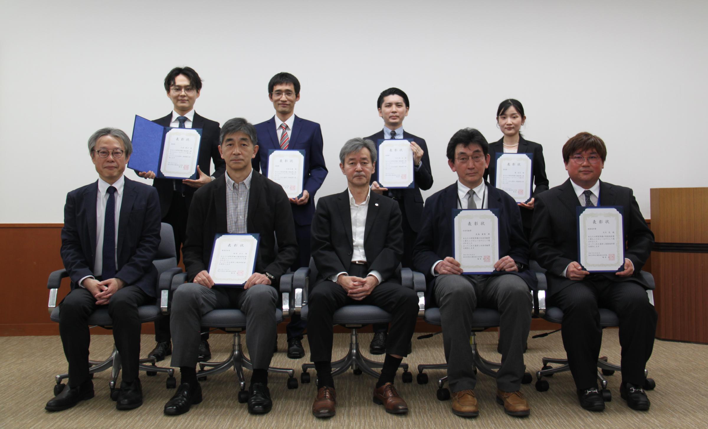 (後列左から)久保講師、田原准教授、大久保助教、楊准教授 (前列左から)四方副学長、新井教授、梅原学長、光島教授、大竹准教授