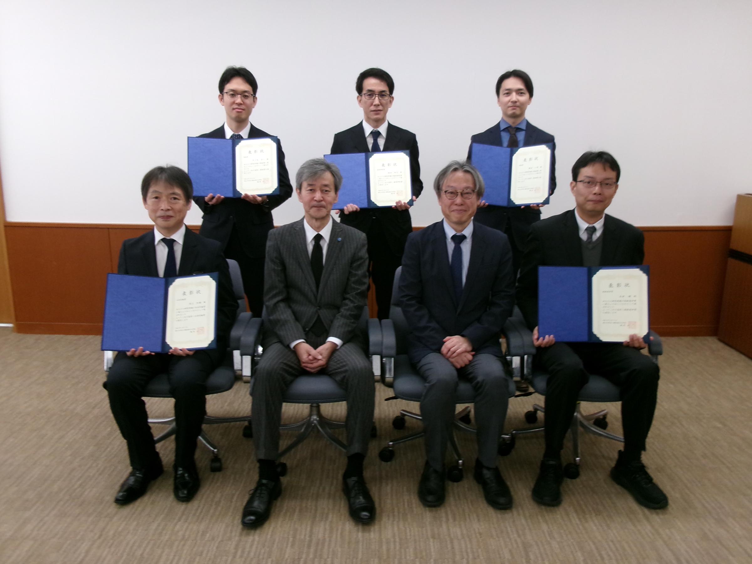（後列左から）多々良准教授、堀切教授、横田講師、　（前列左から）濱上教授、梅原学長、四方副学長、本倉教授