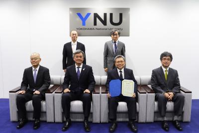 前列左から藤谷様、長谷部学長、永井様、向井教授。後列左から中村学長補佐、大門理事。