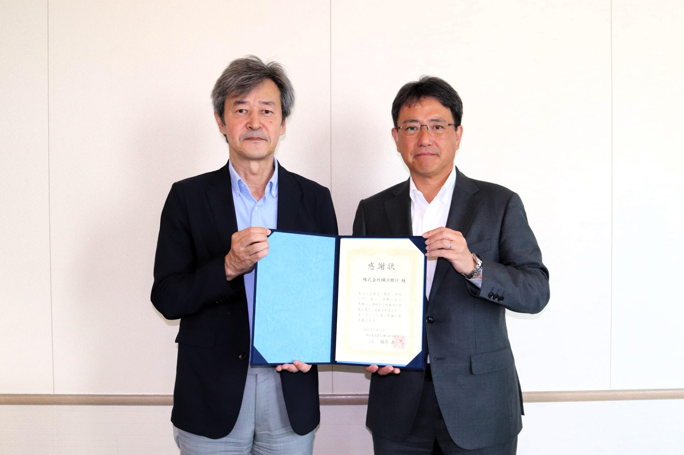 株式会社横浜銀行 代表取締役頭取 片岡 達也様(右)と、梅原学長(左)