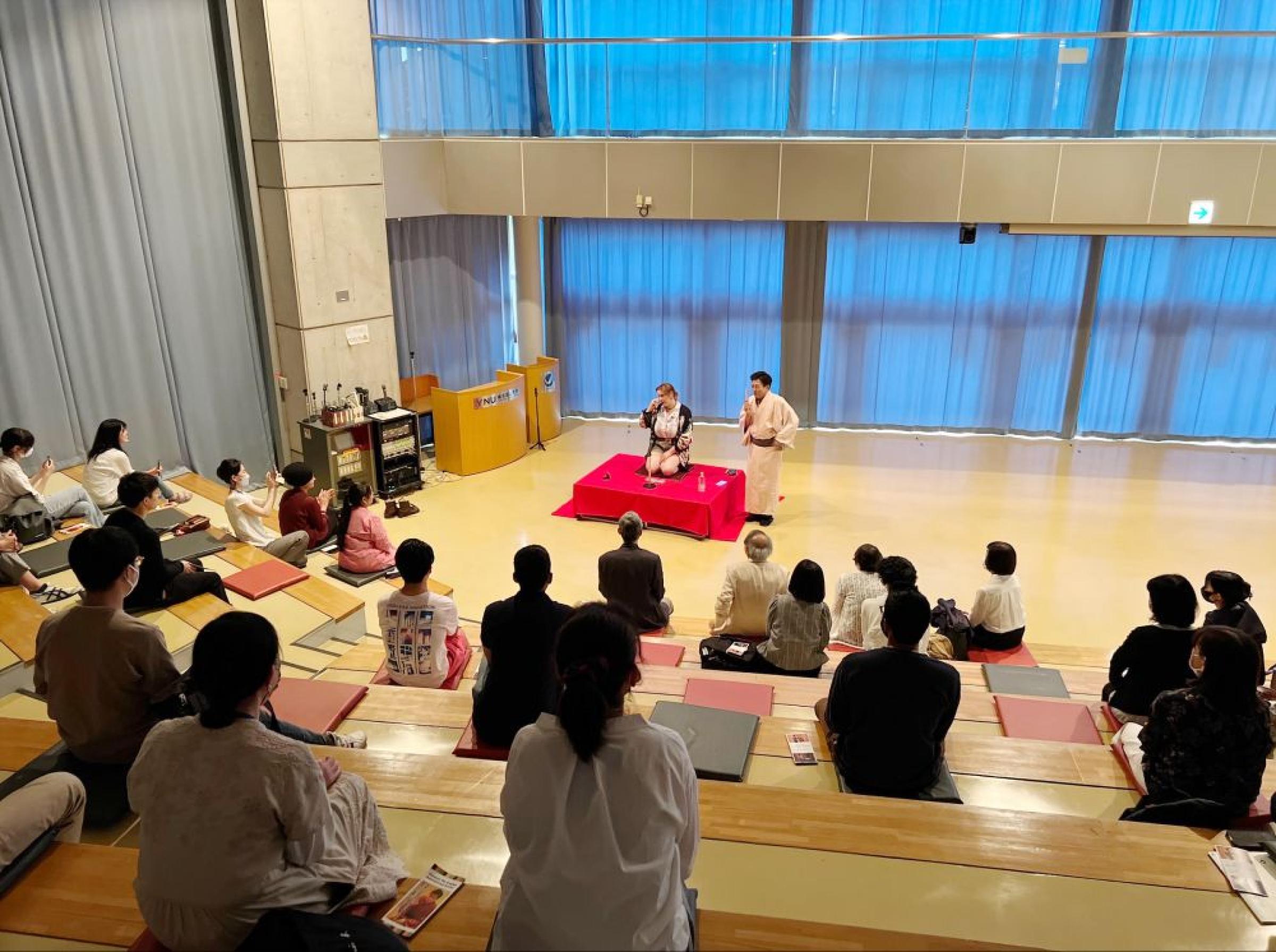 International student performing a rakugo as an audience looks on
