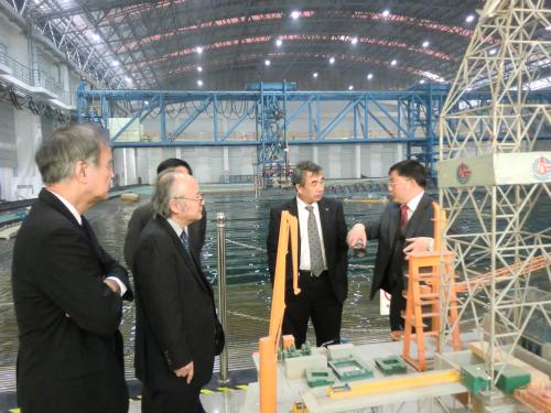 最新式の実験水槽の説明をする陳副校長(右端)