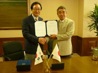 協定書サイン後、固く握手
