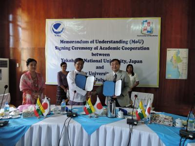 Rector Maung Thynn and Vice-President Yamada shake hands after the signing ceremony
