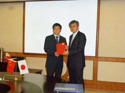 ECNU President Chen (left) and YNU President Hasebe(right) exchanging commemorative gifts after disc