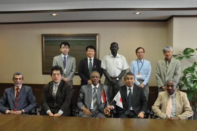 Dr. Mohamed E. Hamza and President Suzuki hold national flags with their hands.