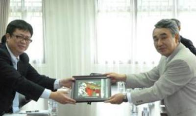 会見を終え記念品を交換する李副学長と鈴木学長