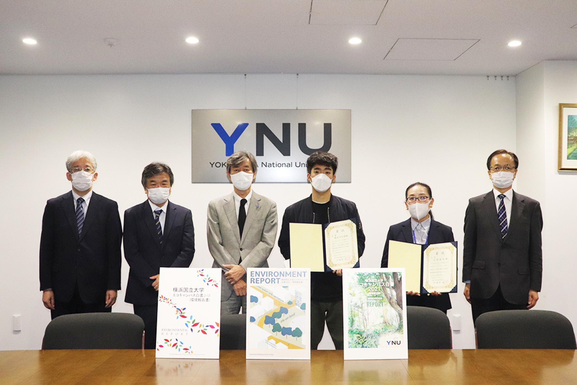 (左より)関崎事務局長、髙木理事、梅原学長、1位の織田さん、3位の山田さん、大堀施設部長