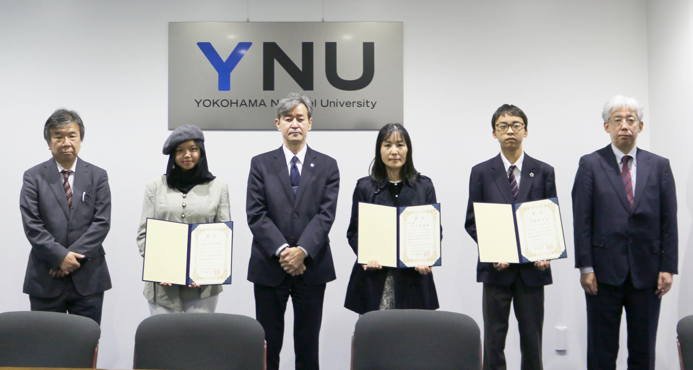(左より)髙木理事、2位Alisha Savairaさん、梅原学長、1位鈴木香織さん、3位佐藤慶幸さん、関崎事務局長