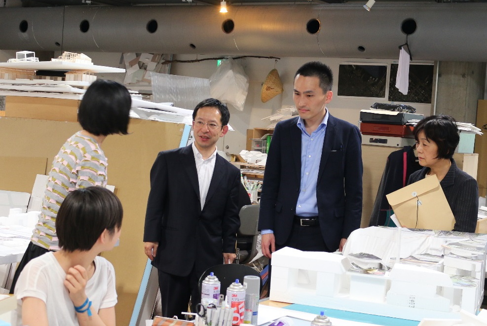 Y-GSAスタジオで寺田特任教員(准教授)から説明を受ける吉田企画官(左)と今野係長(右)