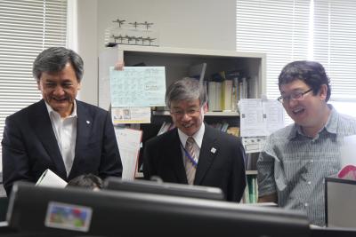 吉岡准教授(右)から情報セキュリティ研究について説明を受ける常盤高等教育局長(中央)と長谷部学長(左)